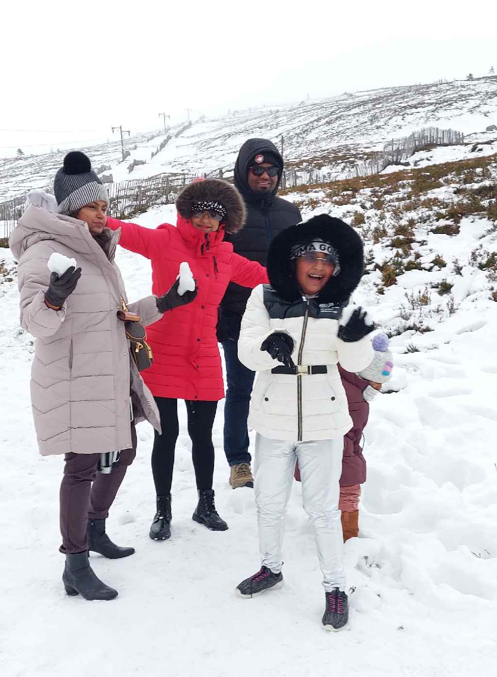 Friendly Highland Tours guests enjoying snow in the Scottish Highlands