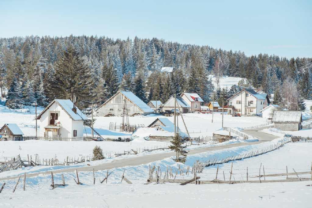 Quiet Highland village street with snow-covered buildings during winter