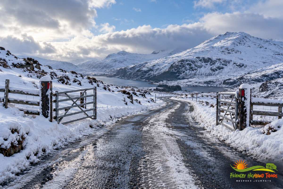 Snow-covered Highland road with icy patches and mountain scenery during winter